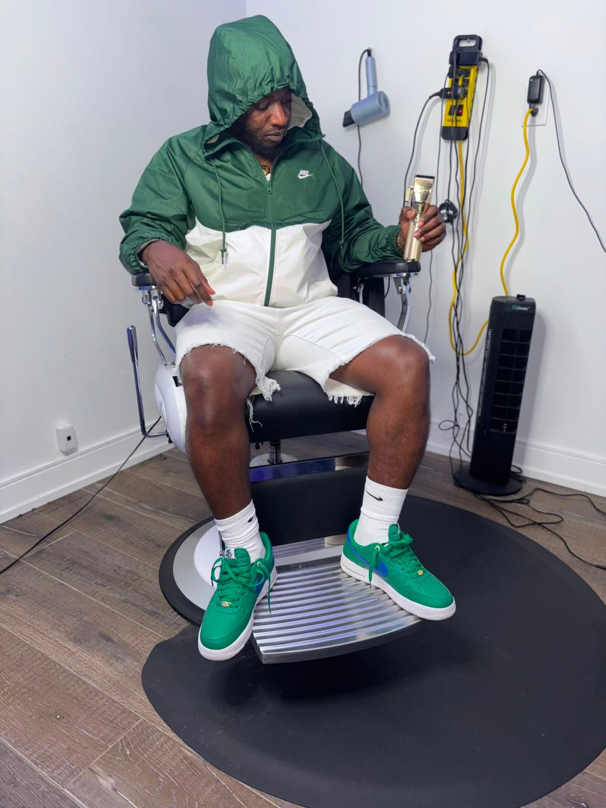 Imar, professional barber, seated in the chair with clippers in hand