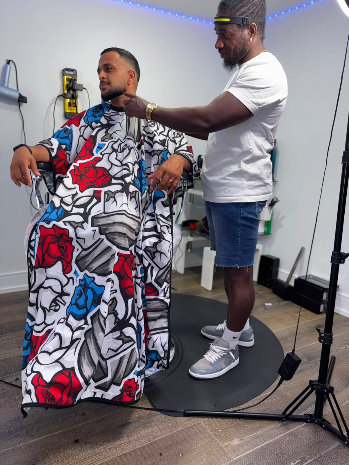 Barber trimming a client's beard in the studio